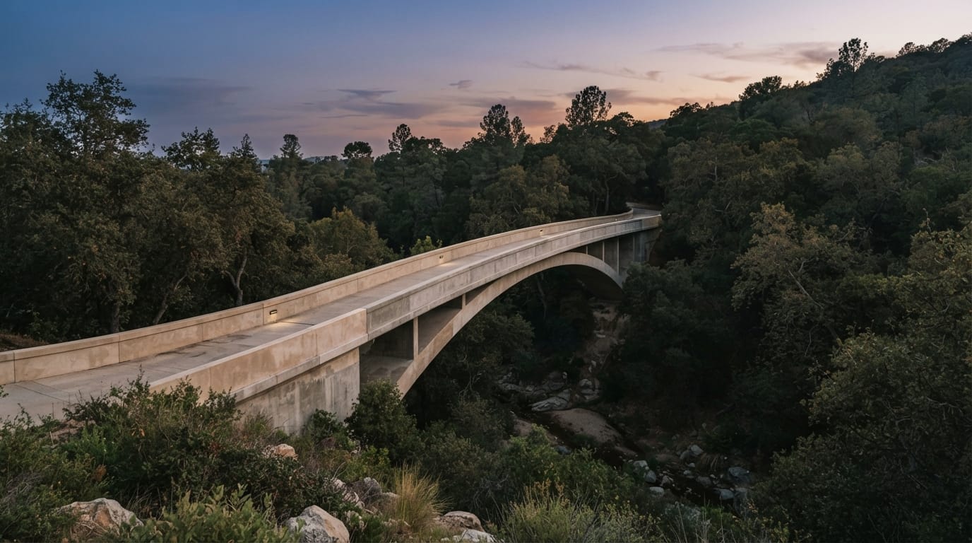 An elegant arched concrete bridge spanning a wooded arroyo at dusk, evoking Pasadena’s history